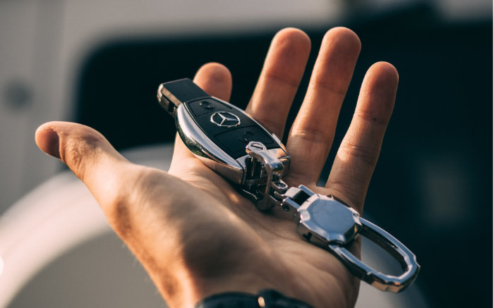 En hand som håller en bilnyckel