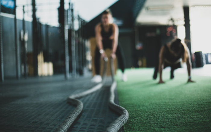 En person utför övningar med tunga rep i ett gym